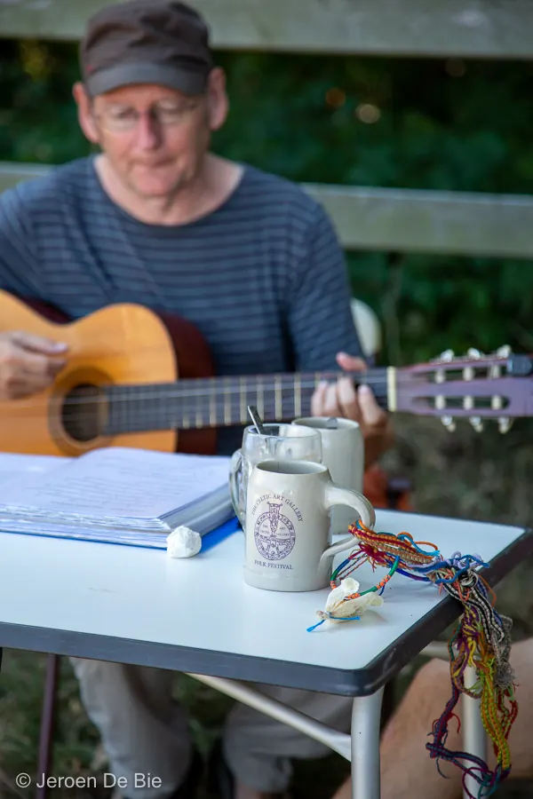 Gitaar, bekers en een setlist op een tafel op het festival