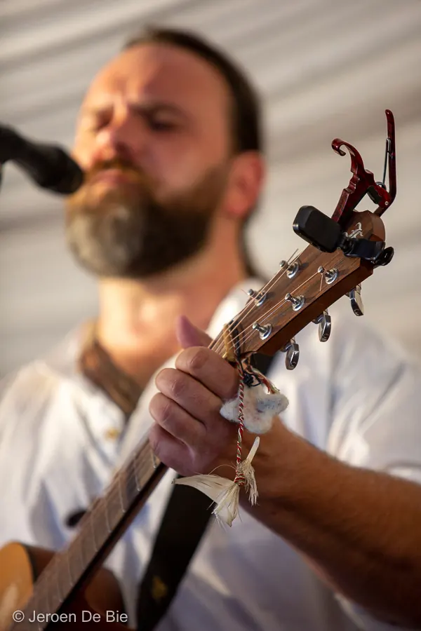 Muzikant met gitaar op het podium van Folkfestival Ham